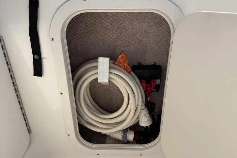 Slide: The Image of Storage compartment in a 2000 Chaparral Signature 240 boat with coiled hose and accessories. - 21
