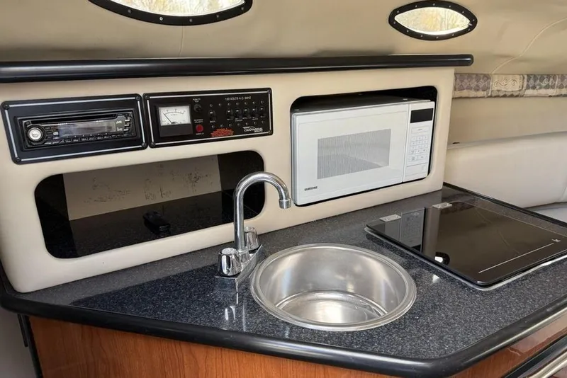 Slide: The Image of 2000 Chaparral Signature 240 boat interior with kitchenette, sink, microwave, and control panel. - 24