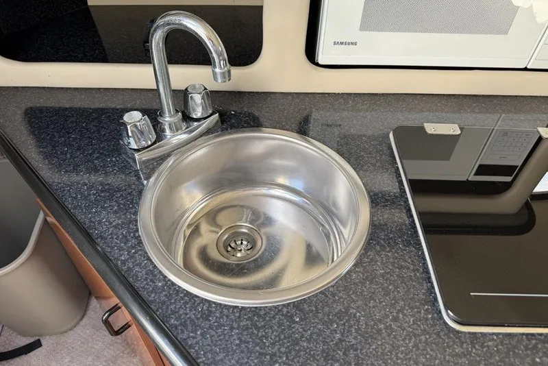 Slide: The Image of Stainless steel sink and faucet in 2000 Chaparral Signature 240 boat kitchen. - 26