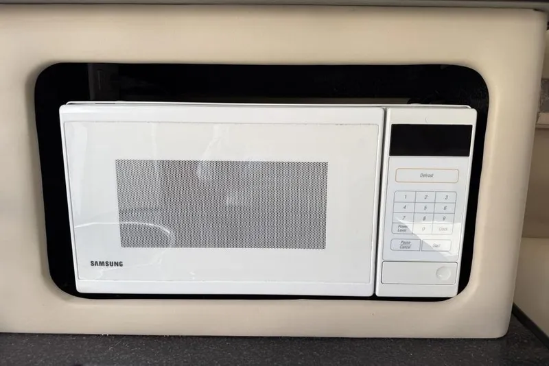 Slide: The Image of White Samsung microwave installed in a 2000 Chaparral Signature 240 boat interior. - 27