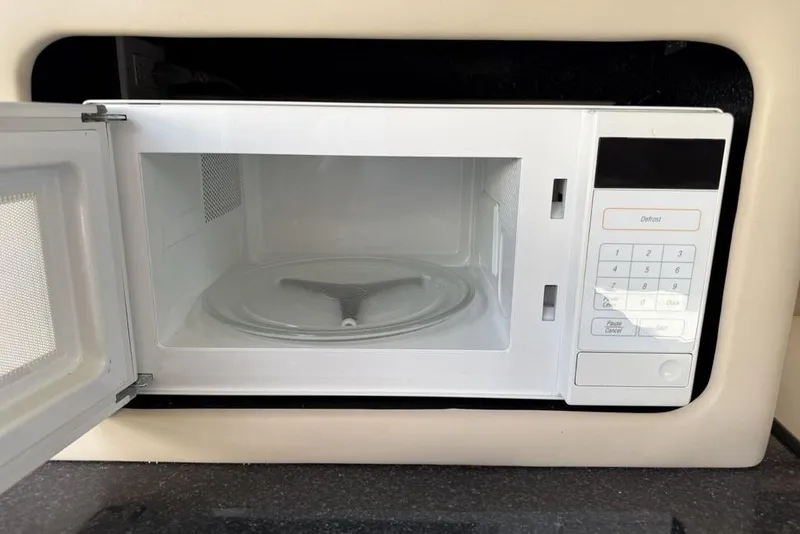 Slide: The Image of Open microwave inside a 2000 Chaparral Signature 240 boat kitchen area. - 28