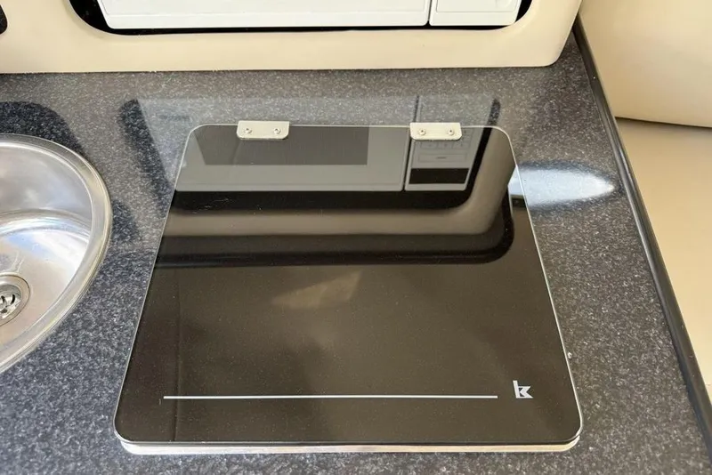 Slide: The Image of Chaparral Signature 240 (2000) boat interior with sleek black stove cover and sink. - 29