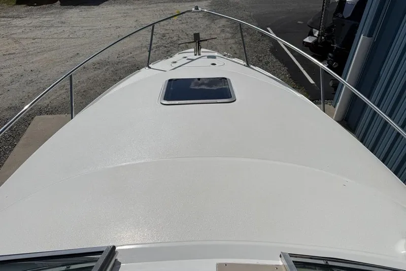 Slide: The Image of 2000 Chaparral Signature 240 boat deck with hatch, docked near a building. - 3