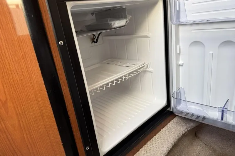 Slide: The Image of Open refrigerator inside a 2000 Chaparral Signature 240 boat cabin. - 33