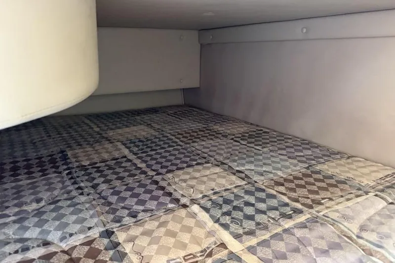 Slide: The Image of Interior cabin view of a 2000 Chaparral Signature 240 boat with patterned bedding. - 36