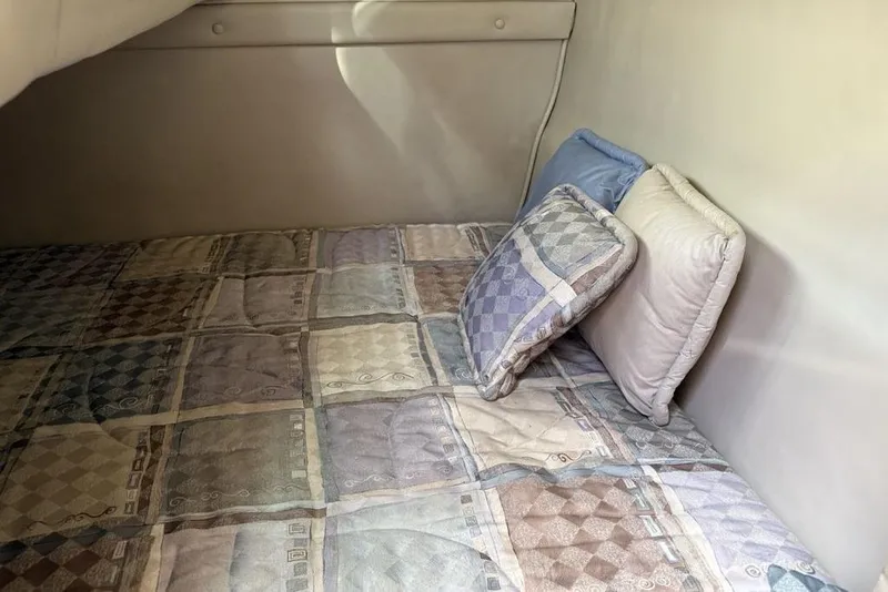 Slide: The Image of Interior cabin of 2000 Chaparral Signature 240 with patterned bedding and pillows. - 40
