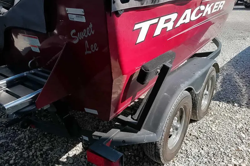 Slide: The Image of 2018 Tracker Targa V-18 Combo boat on trailer, red exterior, gravel background. - 11