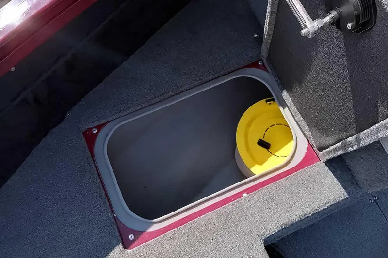 Slide: The Image of 2018 Tracker Targa V-18 Combo boat storage compartment with yellow container. - 17