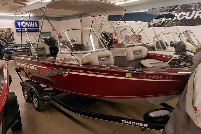 Slide: The Image of 2018 Tracker Targa V-18 Combo boat in showroom, red exterior, on trailer. - 2