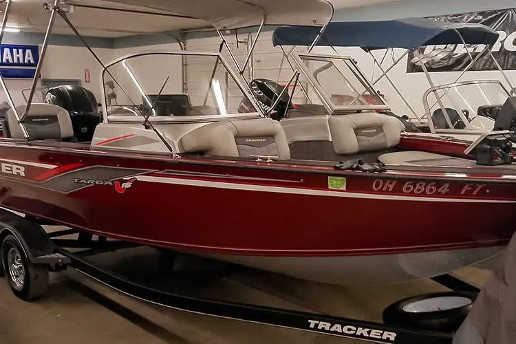 Slide: The Image of 2018 Tracker Targa V-18 Combo boat in showroom, red exterior, on trailer. - 3