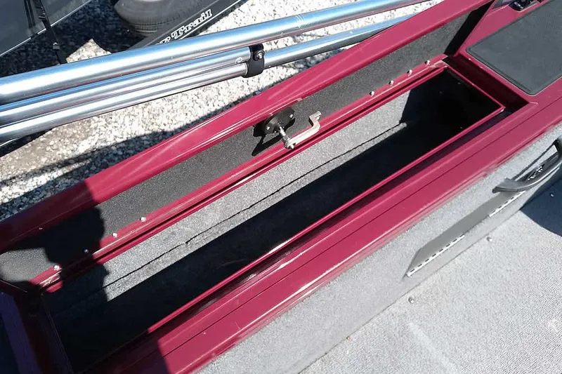 Slide: The Image of 2018 Tracker Targa V-18 Combo boat storage compartment with open lid and fishing rod holders. - 39