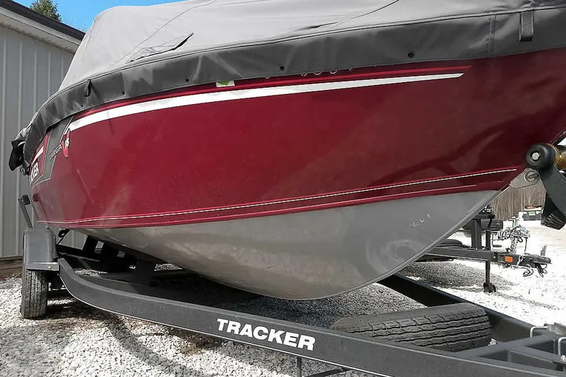 Slide: The Image of 2018 Tracker Targa V-18 Combo boat with cover on trailer, parked outdoors. - 8