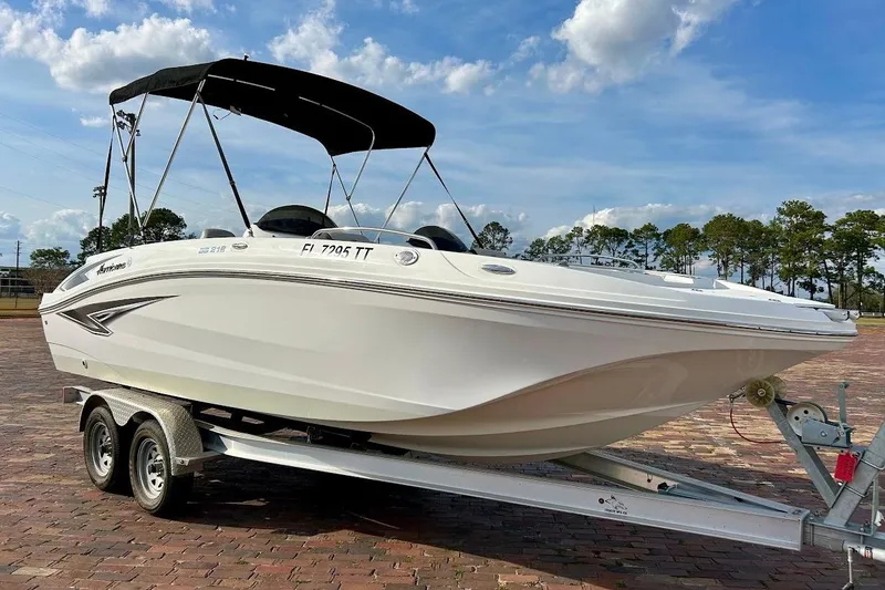 The Image of 2024 Hurricane Sundeck Sport 218 OB boat on trailer under blue sky. - 1