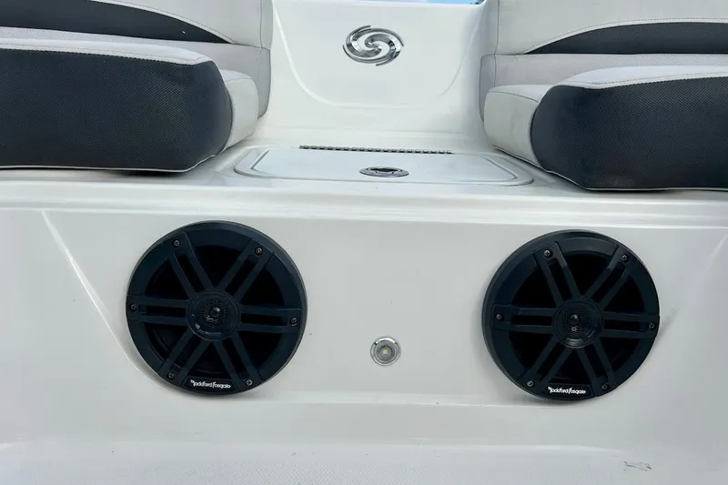 Slide: The Image of 2024 Hurricane Sundeck Sport 218 OB boat interior with dual speakers and cushioned seating. - 19
