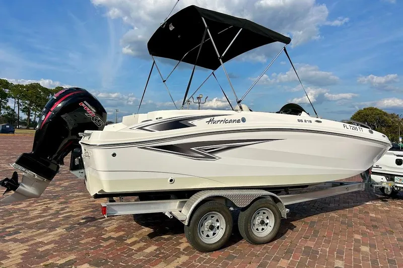 Slide: The Image of 2024 Hurricane Sundeck Sport 218 OB boat on trailer, featuring sleek design and powerful outboard motor. - 2