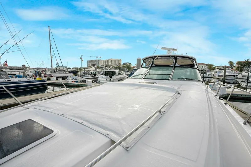 Slide: The Image of 2003 Sea Ray Sundancer 460 yacht docked at a marina under a clear blue sky. - 13