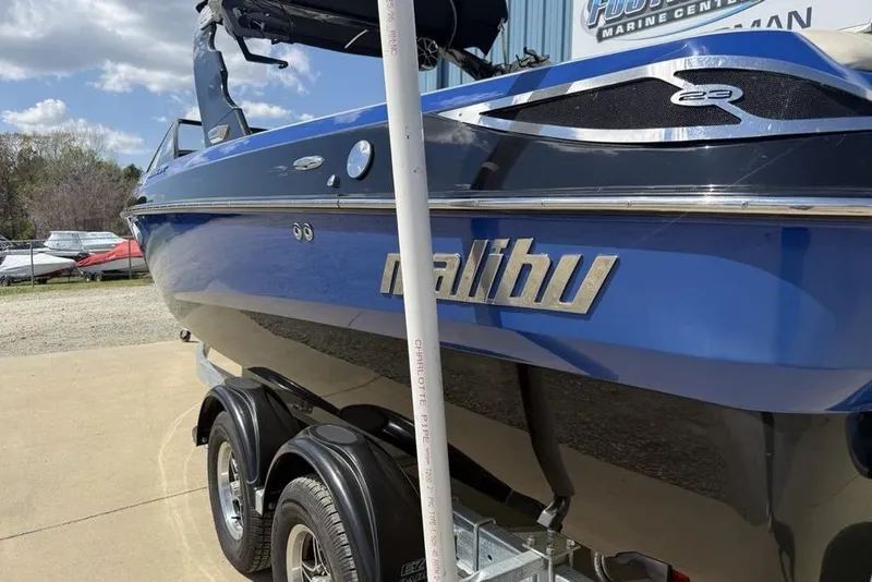 Slide: The Image of 2008 Malibu Sunscape 23 LSV boat on trailer, blue exterior, parked outdoors. - 6