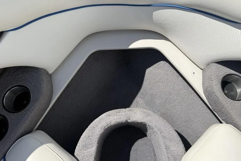 Slide: The Image of Interior of a 2008 Malibu Sunscape 23 LSV boat, featuring gray carpet and white upholstery. - 9