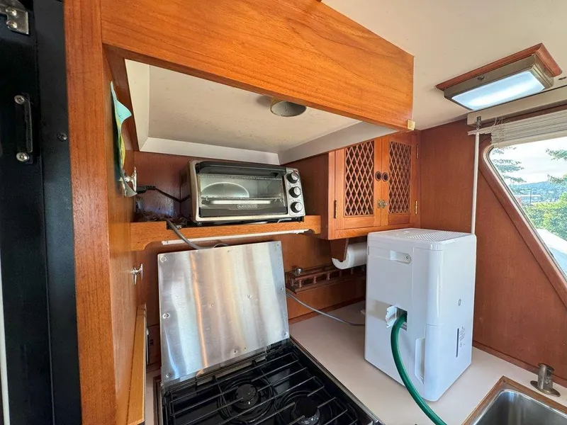 Slide: The Image of Galley kitchen in 1980 Ocean Alexander 50 MK1 yacht with appliances and wooden cabinetry. - 12