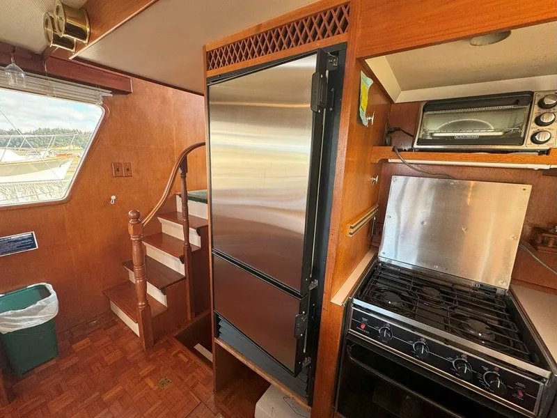 Slide: The Image of Interior of 1980 Ocean Alexander 50 MK1 yacht kitchen with stainless appliances and wooden cabinetry. - 14