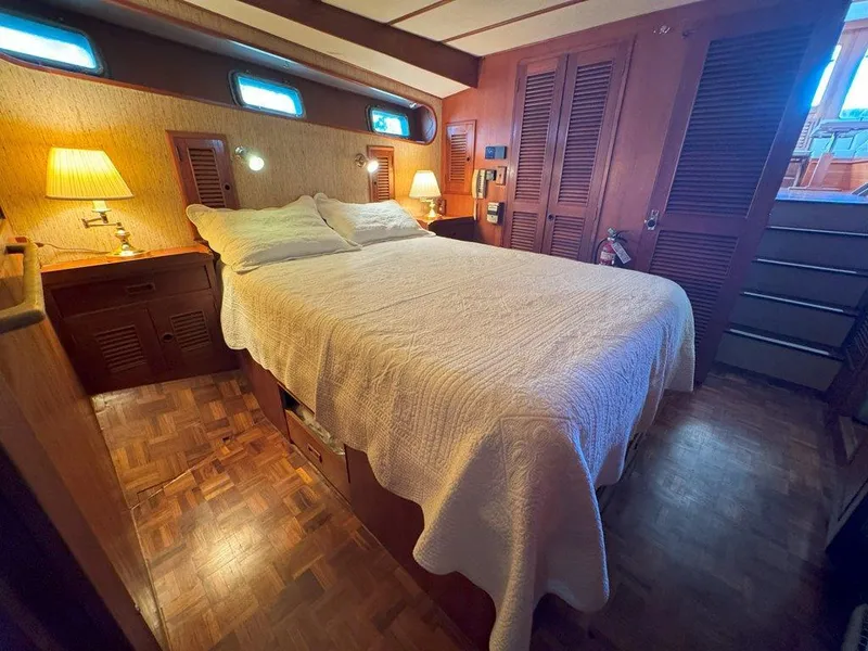Slide: The Image of Cozy bedroom in 1980 Ocean Alexander 50 MK1 yacht with wood accents and soft lighting. - 26