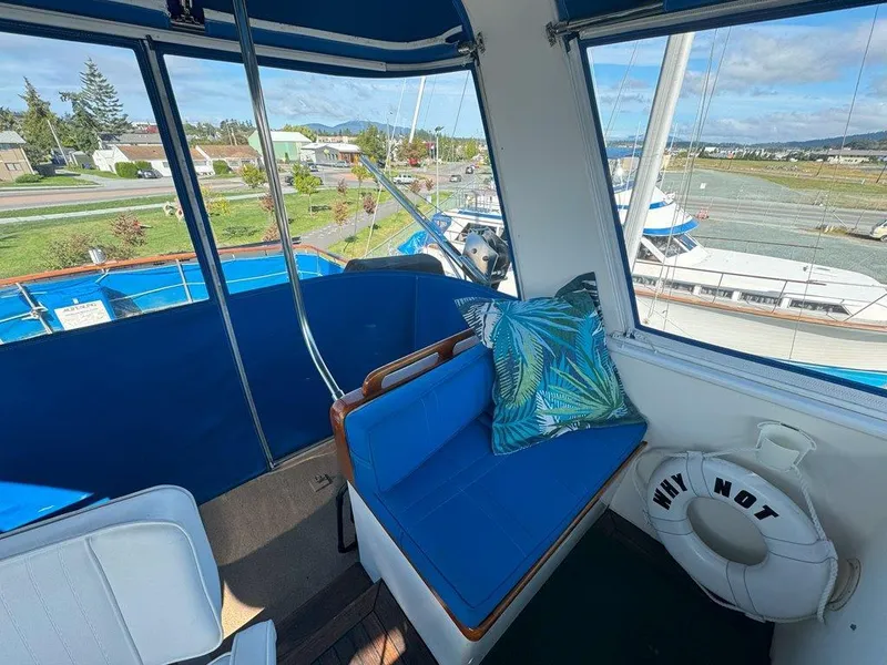 Slide: The Image of Interior view of 1980 Ocean Alexander 50 MK1 yacht with blue seating and scenic marina backdrop. - 40