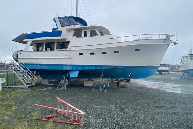 Slide: The Image of 1980 Ocean Alexander 50 Mark I yacht on dry dock, blue and white hull, overcast sky. - 49
