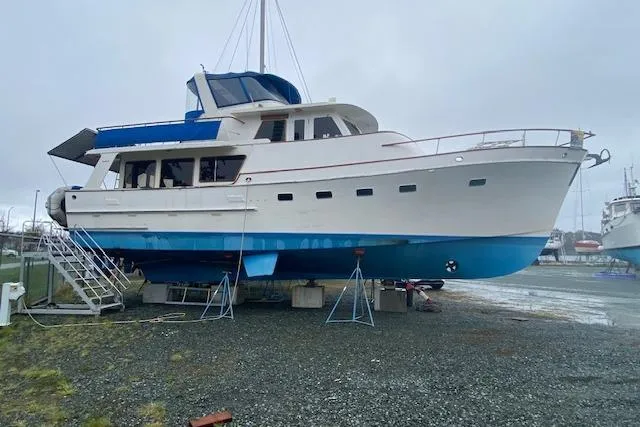 Slide: The Image of 1980 Ocean Alexander 50 Mark I yacht on dry dock, white and blue hull. - 50