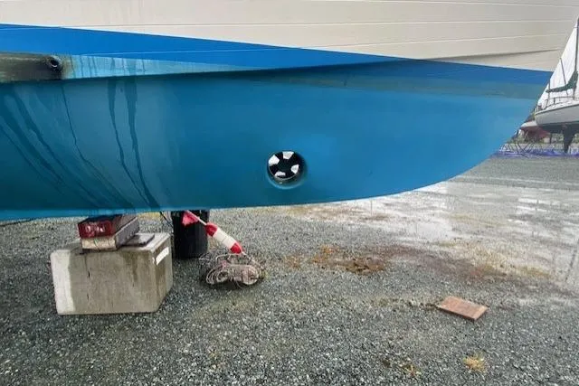 Slide: The Image of Ocean Alexander 50 Mark I 1980 boat hull with visible thruster on gravel surface. - 52