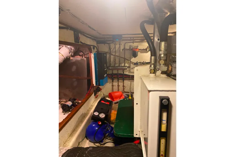 Slide: The Image of Engine room of 1980 Ocean Alexander 50 Mark I yacht, featuring mechanical equipment and piping. - 68