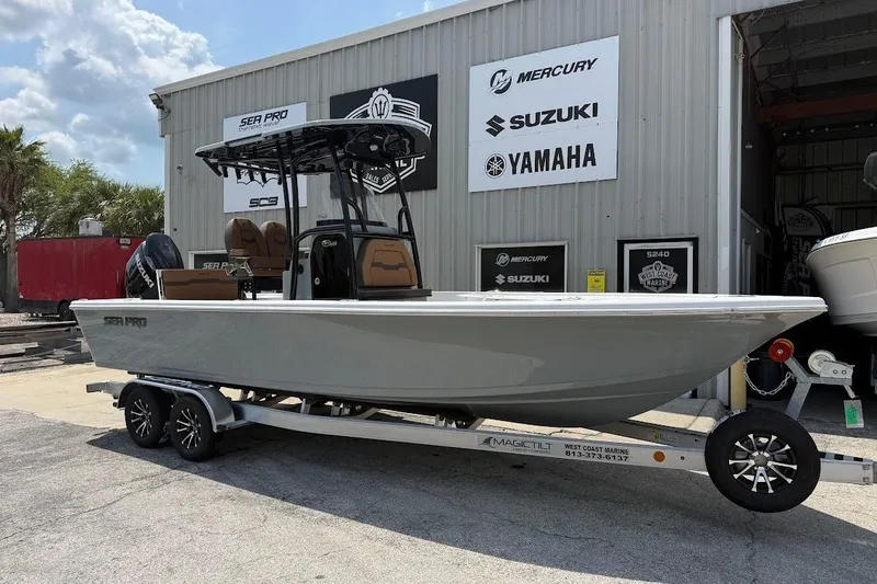 The Image of 2026 Sea Pro 250 Bay boat on trailer outside marine dealership. - 1
