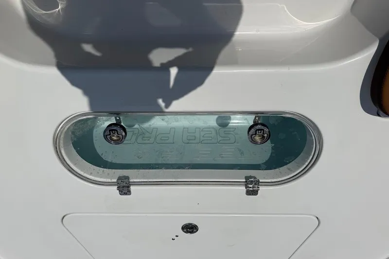Slide: The Image of Livewell on 2026 Sea Pro 250 Bay boat, featuring clear lid and secure latches. - 12