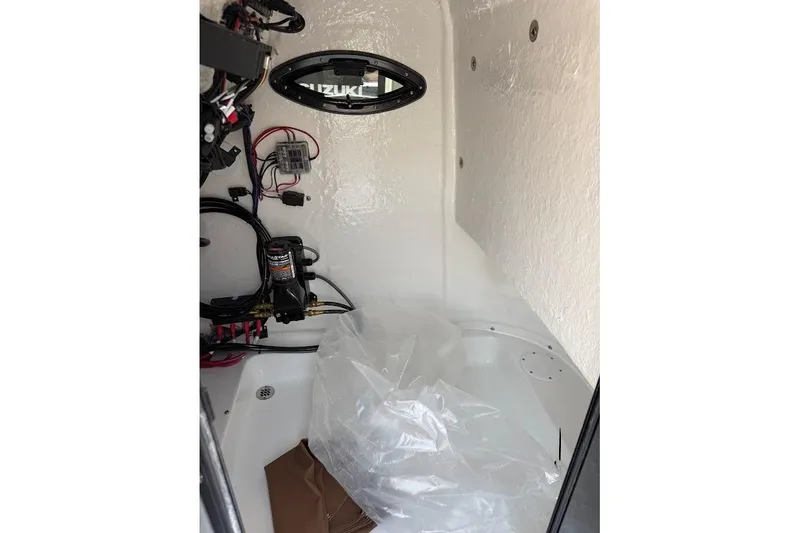 Slide: The Image of Interior view of 2026 Sea Pro 250 Bay boat's compartment with wiring and equipment. - 13