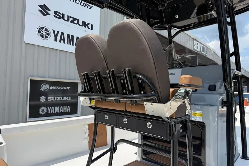 Slide: The Image of 2026 Sea Pro 250 Bay boat interior with rod holders and dual seats, featuring Suzuki and Yamaha signage. - 7