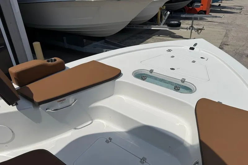 Slide: The Image of 2026 Sea Pro 250 Bay boat interior with brown seating and storage compartments. - 9