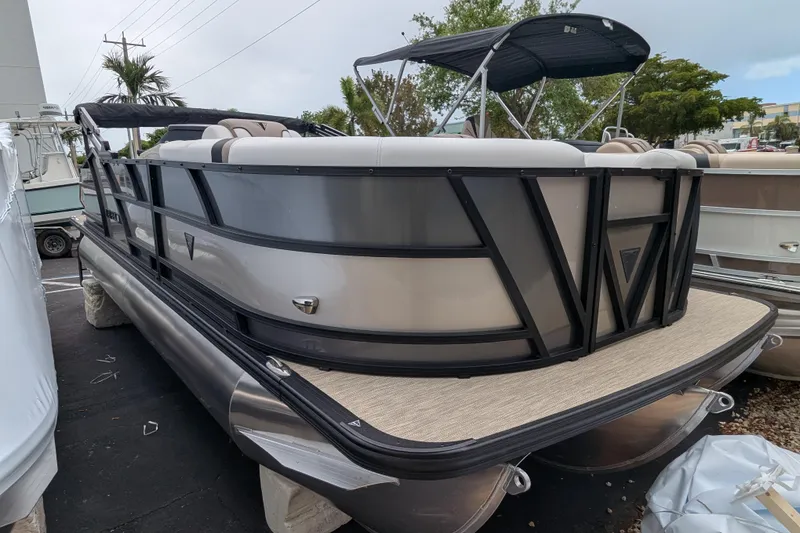 The Image of 2026 Trifecta 21C SS pontoon boat with sleek design and canopy, parked outdoors. - 0