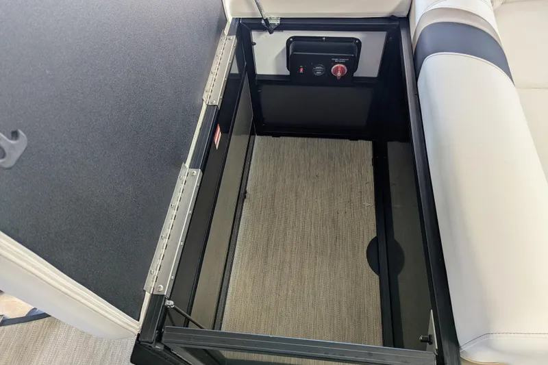 Slide: The Image of Open storage compartment in 2026 Trifecta 21C SS boat, featuring a control panel. - 13