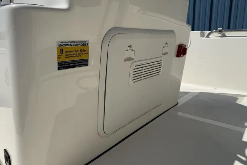 Slide: The Image of 2023 Bulls Bay 2400 boat interior showing capacity label and storage compartment. - 18
