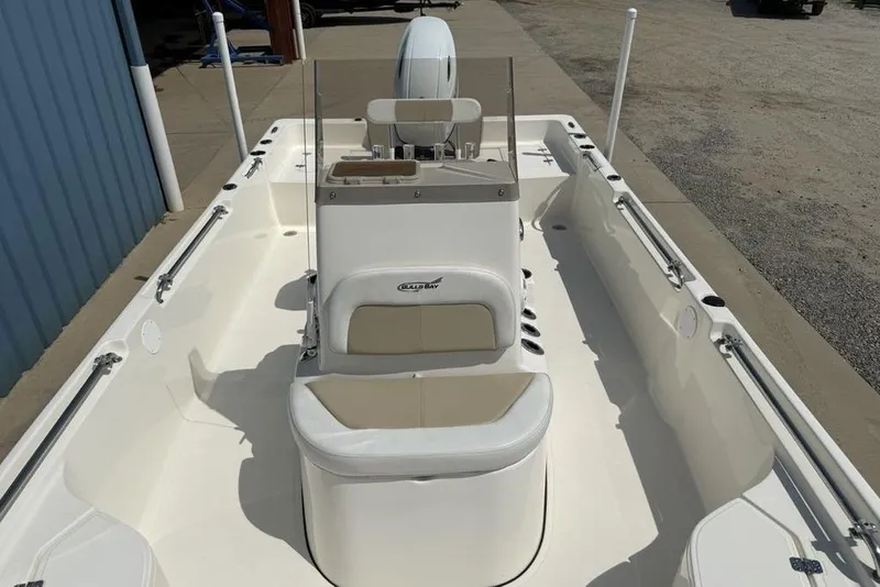 Slide: The Image of 2023 Bulls Bay 2400 boat interior with seating and console, docked on concrete. - 20