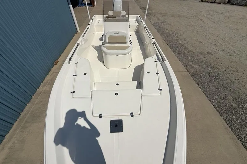 Slide: The Image of 2023 Bulls Bay 2400 boat, white deck, outdoor setting, shadow visible. - 31