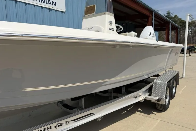 Slide: The Image of 2023 Bulls Bay 2400 boat on trailer, parked outside a blue building. - 6