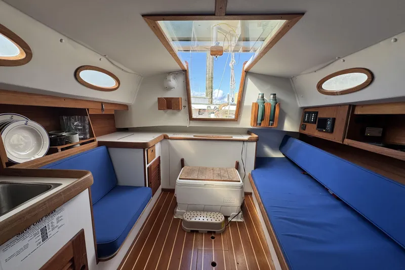 Slide: The Image of Interior of 2017 Alerion Express 28 sailboat with blue seating and wooden accents. - 15