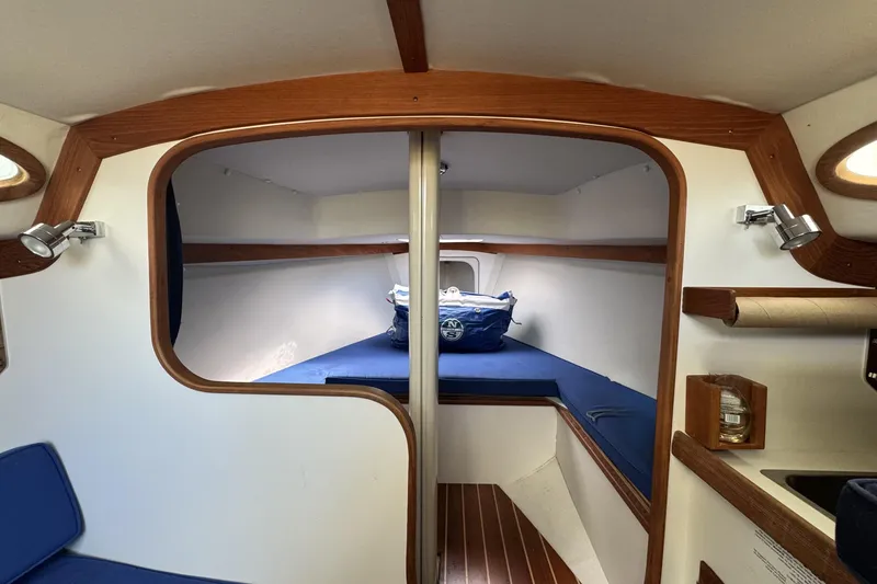 Slide: The Image of Cozy cabin interior of 2017 Alerion Express 28 sailboat with blue cushions and wooden accents. - 16