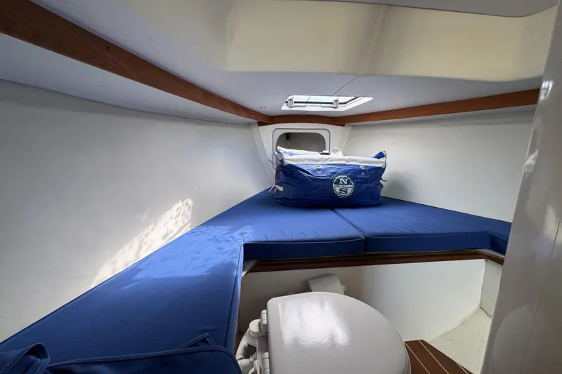Slide: The Image of Interior cabin of 2017 Alerion Express 28 sailboat with blue cushions and storage bag. - 17