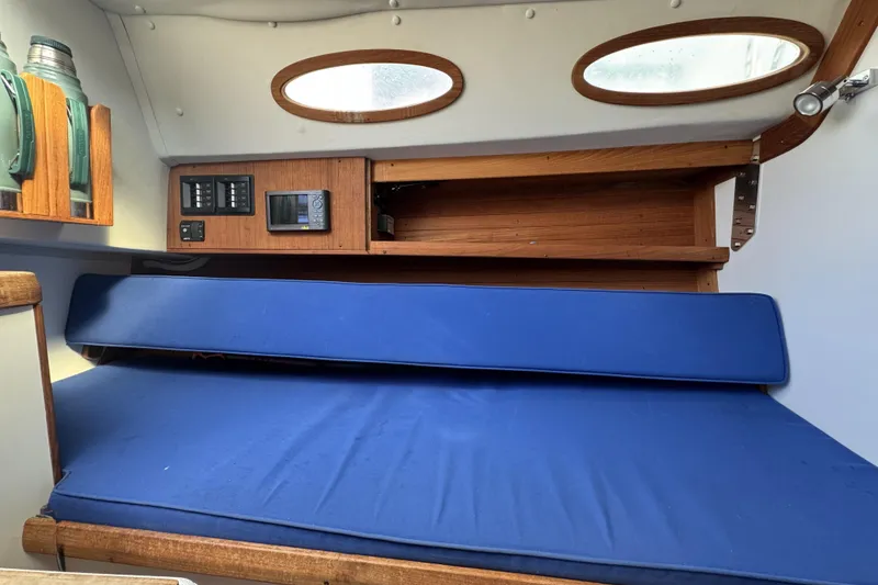 Slide: The Image of Interior cabin of 2017 Alerion Express 28 sailboat with blue cushions and wooden shelves. - 19