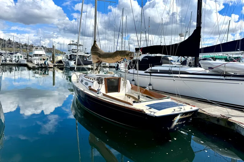 Slide: The Image of 2017 Alerion Express 28 sailboat docked in a marina under a partly cloudy sky. - 2