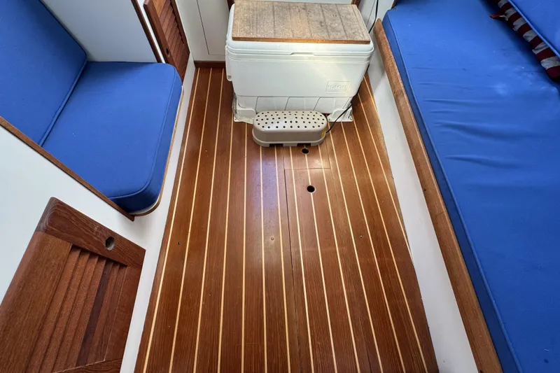 Slide: The Image of Interior of 2017 Alerion Express 28 sailboat with wooden flooring and blue seating. - 20