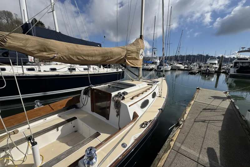 Slide: The Image of 2017 Alerion Express 28 sailboat docked at a marina under a partly cloudy sky. - 3