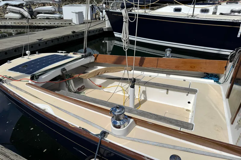 Slide: The Image of 2017 Alerion Express 28 sailboat docked, featuring a solar panel and wooden accents. - 5
