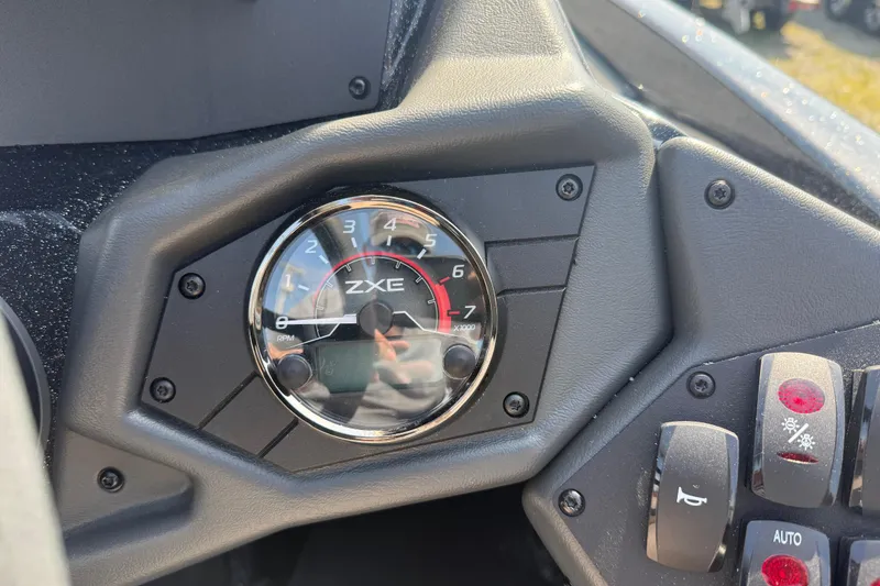 Slide: The Image of Dashboard of 2026 Skeeter ZXE21 boat featuring RPM gauge and control switches. - 12